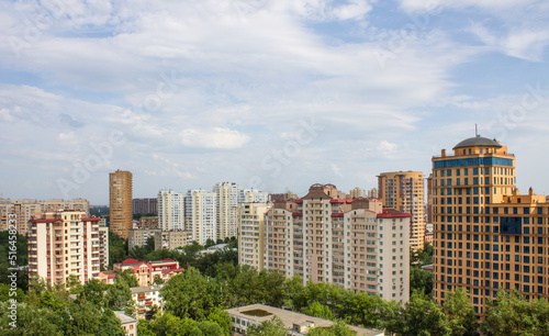 Cityscape with modern tall residential buildings on a sunny summer day and blue sky with clouds