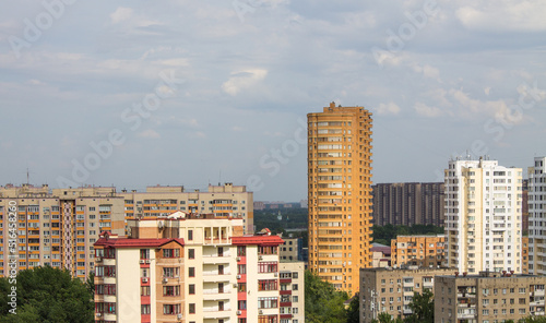Panoramic top view - cityscape with modern buildings and lush tree foliage on a clear sunny summer day and blue sky © Inna