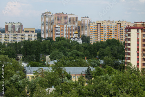 City landscape - modern tall houses among green trees in Reutov in the Moscow region on a summer day and cloudy sky