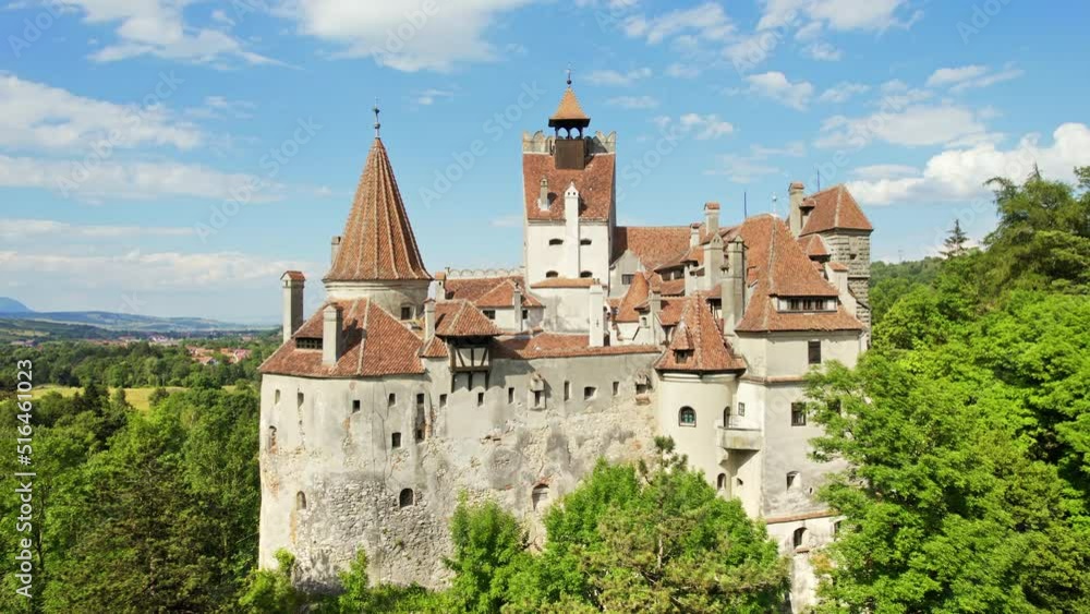 Aerial drone view of The Bran Castle in Romania. Medieval castle in Carpathians, green trees around Aerial drone view of The Bran Castle in Romania. Medieval castle in Carpathians, green trees around
