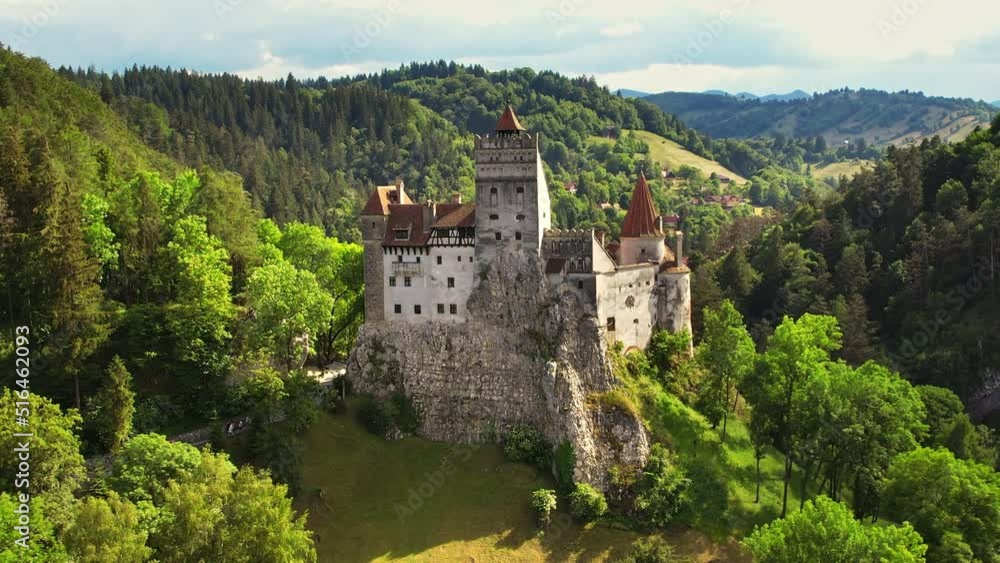 Aerial drone view of The Bran Castle in Romania. Medieval castle in Carpathians, green trees around Aerial drone view of The Bran Castle in Romania. Medieval castle in Carpathians, green trees around