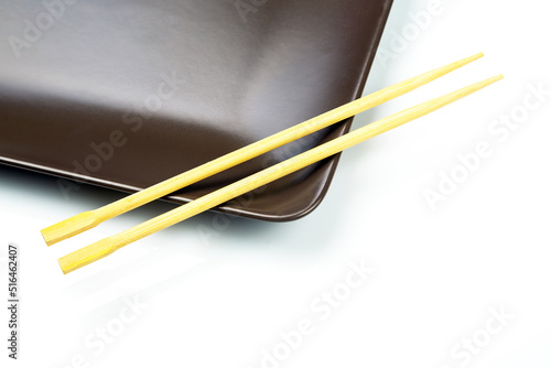 bamboo chopsticks lie on a ceramic plate. items for food