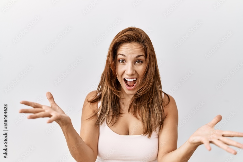 Middle age hispanic woman standing over isolated background celebrating crazy and amazed for success with arms raised and open eyes screaming excited. winner concept Middle age hispanic woman standing over isolated background celebrating crazy and amazed for success with arms raised and open eyes screaming excited. winner concept