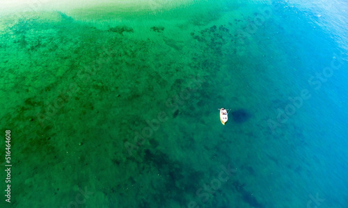 Aerial view on the boat in transparent water lake