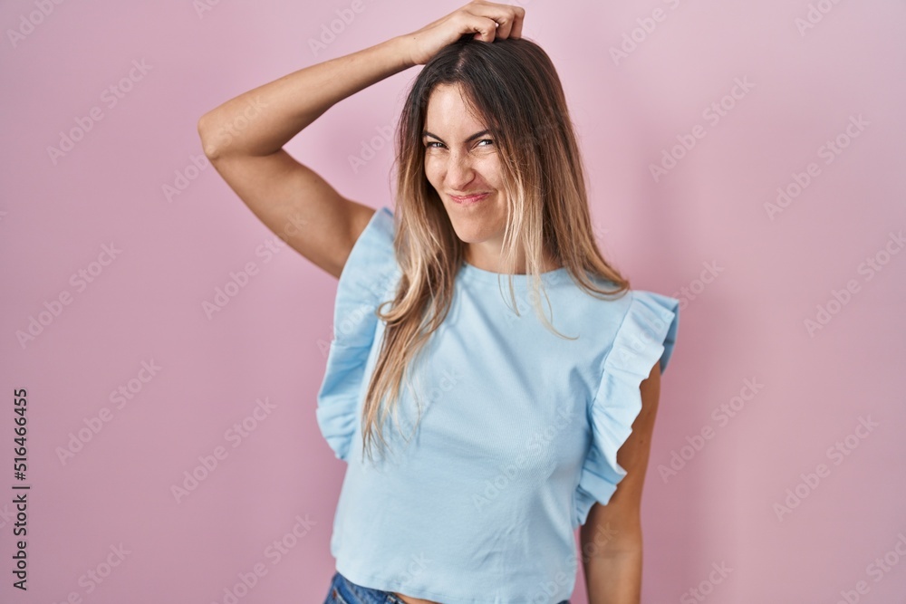 Young hispanic woman standing over pink background confuse and wonder about question. uncertain with doubt, thinking with hand on head. pensive concept. Young hispanic woman standing over pink background confuse and wonder about question. uncertain with doubt, thinking with hand on head. pensive concept.