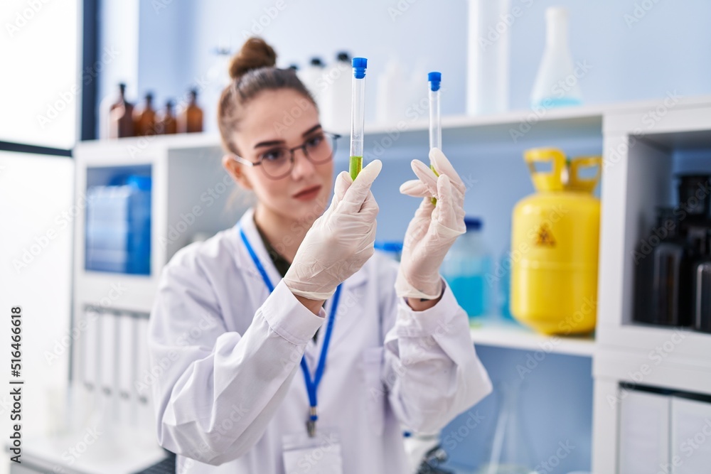 Young woman scientist smiling confident holding test tubes at laboratory Young woman scientist smiling confident holding test tubes at laboratory