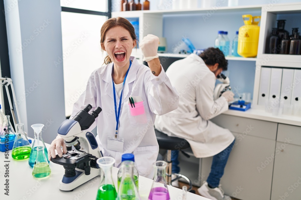 Young two people working at scientist laboratory annoyed and frustrated shouting with anger, yelling crazy with anger and hand raised Young two people working at scientist laboratory annoyed and frustrated shouting with anger, yelling crazy with anger and hand raised