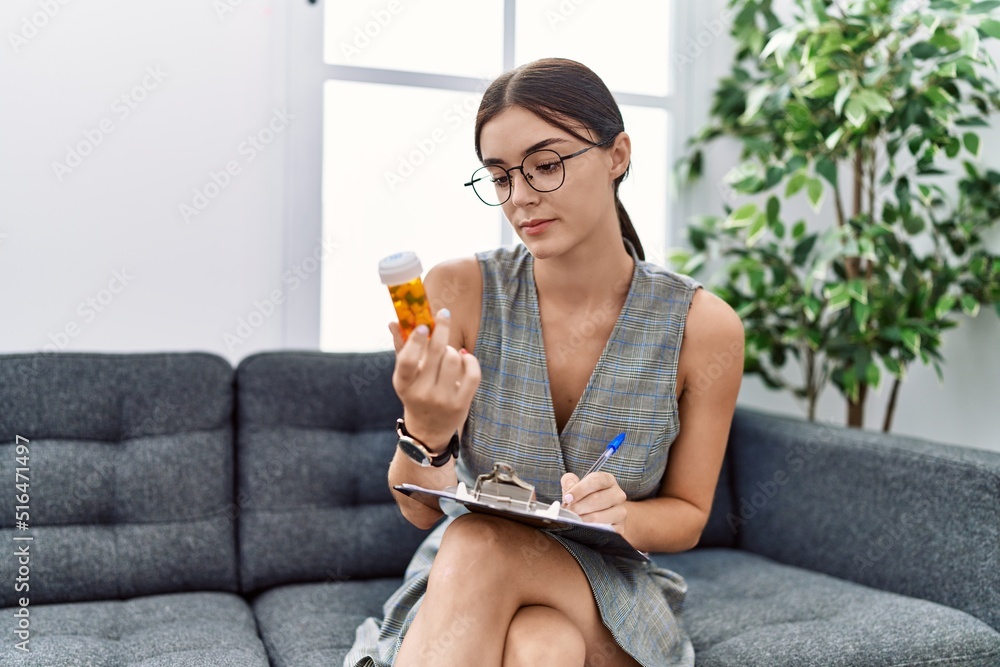 Young hispanic woman doing psychiatry treatment holding pills at pshychiatry clinic Young hispanic woman doing psychiatry treatment holding pills at pshychiatry clinic