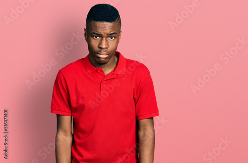 Fotografie, Tablou Young african american man wearing casual red t shirt depressed and worry for distress, crying angry and afraid