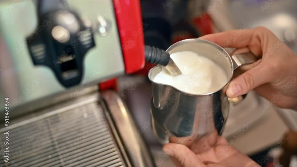Barista steaming milk in a coffee maker. Slow motion Barista steaming milk in a coffee maker. Slow motion