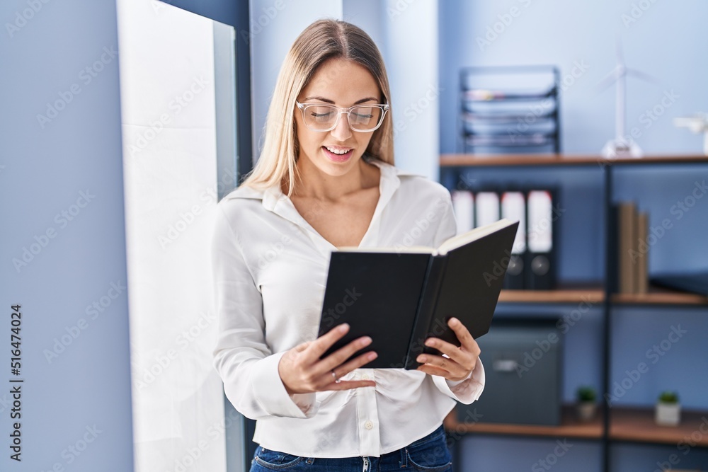 Young woman business worker reading book at office Young woman business worker reading book at office
