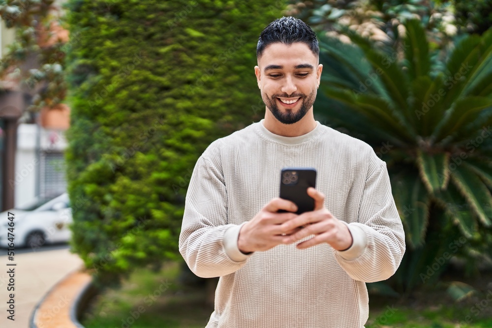 Young arab man smiling confident using smartphone at park Young arab man smiling confident using smartphone at park
