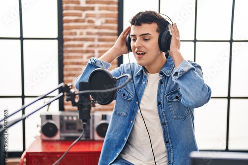 Young non binary man artist singing song at music studio © Krakenimages.com