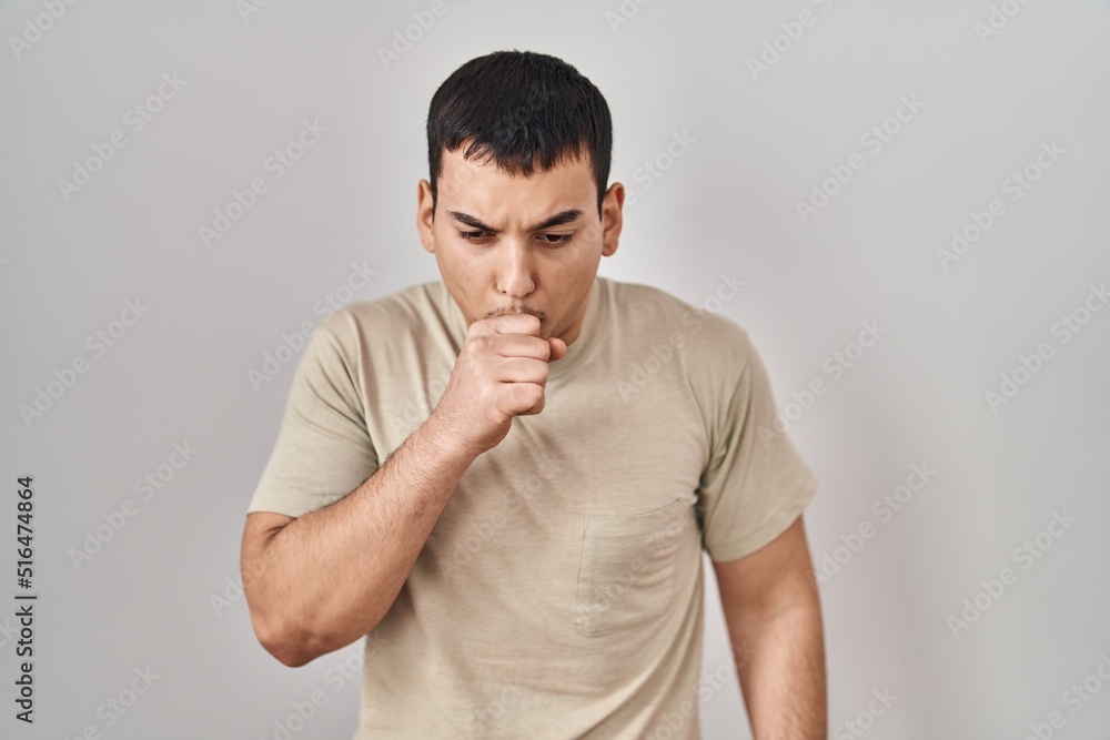 Young arab man wearing casual t shirt feeling unwell and coughing as symptom for cold or bronchitis. health care concept. Young arab man wearing casual t shirt feeling unwell and coughing as symptom for cold or bronchitis. health care concept.