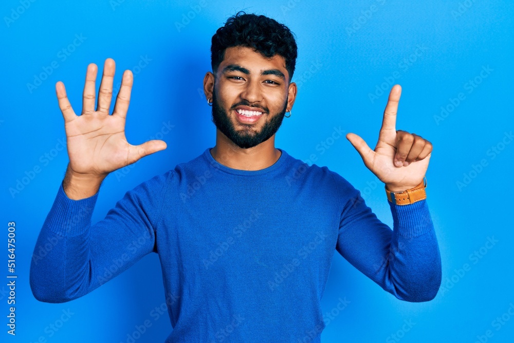 Arab man with beard wearing casual blue sweater showing and pointing up with fingers number seven while smiling confident and happy. Arab man with beard wearing casual blue sweater showing and pointing up with fingers number seven while smiling confident and happy.
