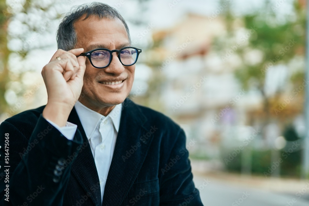 Middle age southeast asian man standing and smiling confident holding glasses at the city Middle age southeast asian man standing and smiling confident holding glasses at the city