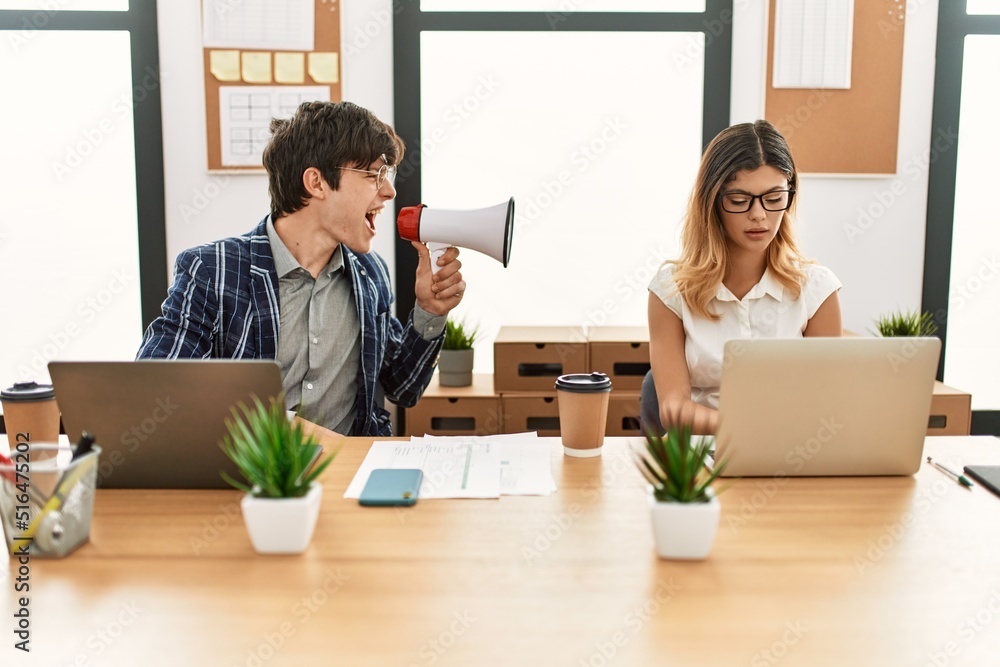 Businessman angry shouting his partner using megaphone at the office. Businessman angry shouting his partner using megaphone at the office.