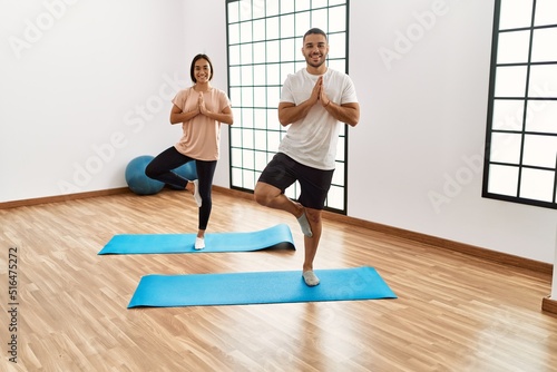 Latin man and woman couple smiling confident training yoga at sport center