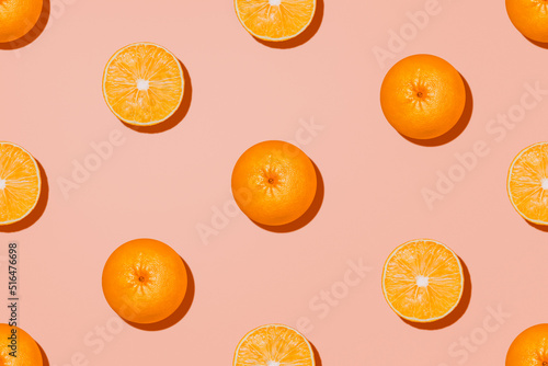 Orange fruit in top view. Halves and whole of oranges on pastel pink background