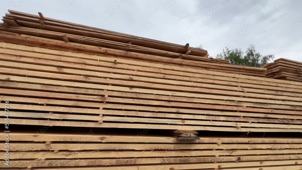 Stacks of boards sawn at the sawmill lie outdoors Stacks of boards sawn at the sawmill lie outdoors