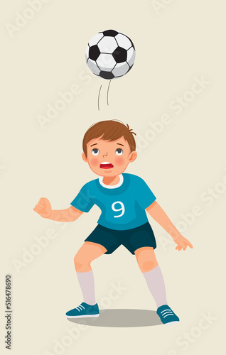 cute little boy playing soccer practicing kicking the football with his head