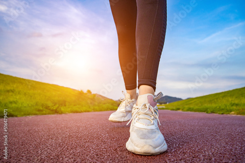 A young Asian girl running towards the sun in the morning