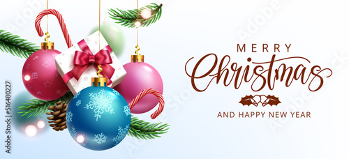 Christmas greeting vector design. Merry christmas text in white space with hanging xmas balls, gift and pine leaves decoration elements for holiday season. Vector illustration.
