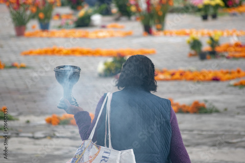 Local mexican woman carrying stove with incense.