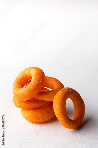 crispy doughnut or donut, crunchy deep fried snack variety which tastes sweet and spicy on a white table top with space for text photo