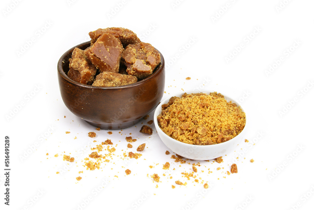 A Wooden Bowl With Jaggery Piece and Jaggery Powder bowl isolated on white background