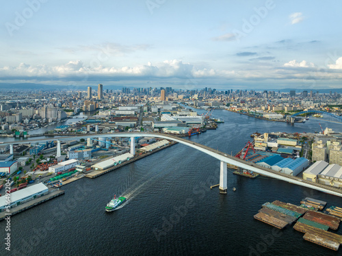Tugboat motors through harbor and warehouses amid city landscape