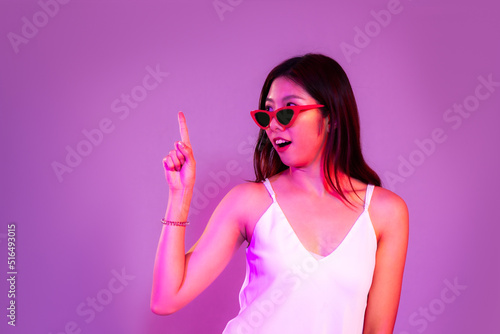 Young asian woman long hair wearing sunglass posing finger pointing and touching on the purple and violet color background.