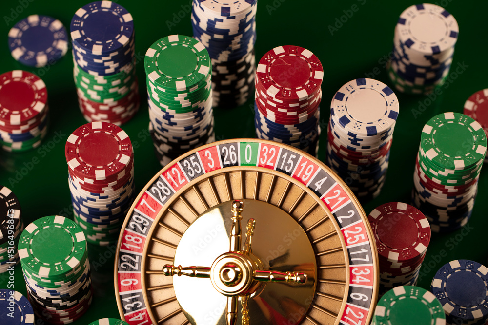 Casino. Gambling games theme. Roulette wheel, dice and poker chips on the casino felt green table. Casino. Gambling games theme. Roulette wheel, dice and poker chips on the casino felt green table.