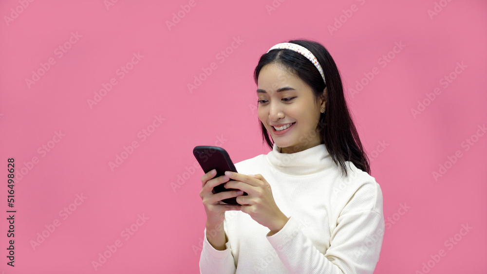 Asian woman smiling and using mobile phone with tablet and excited for online shopping on isolated pink background. Asian woman smiling and using mobile phone with tablet and excited for online shopping on isolated pink background.