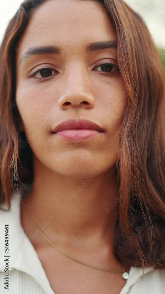 VERTICAL VIDEO: Clouse-up, beautiful girl with brown long hair, tanned skin raises her head and looks straight into the camera. Young women serious look at camera open and confident VERTICAL VIDEO: Clouse-up, beautiful girl with brown long hair, tanned skin raises her head and looks straight into the camera. Young women serious look at camera open and confident