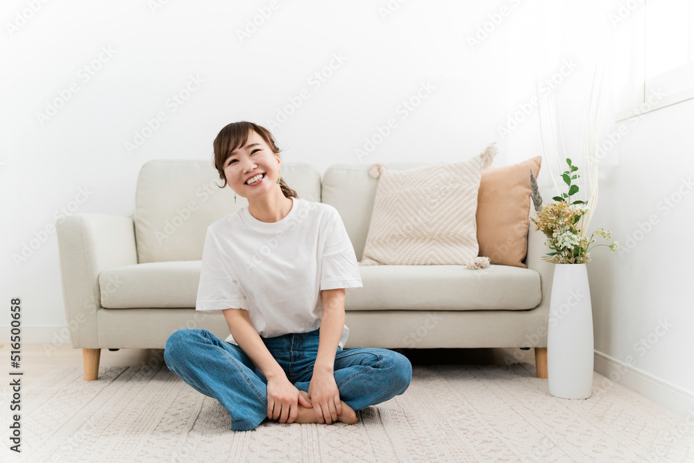 家のカーペットでリラックスするデニム姿の日本人女性（爆笑・笑顔）
