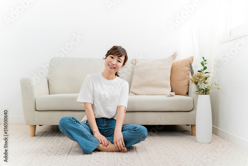 家のカーペットでリラックスする日本人女性（あぐら） 