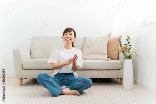 家のカーペットでリラックスするデニム姿の日本人女性（爆笑・笑顔） 