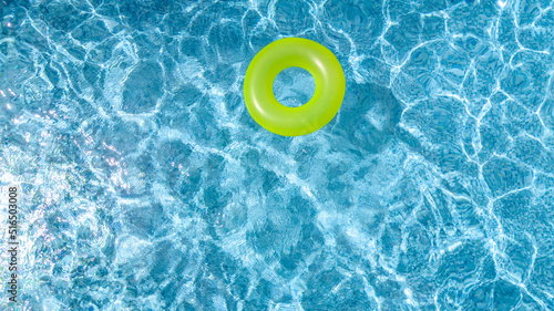 Сolorful inflatable ring donut toy in swimming pool water aerial view from above, family vacation holiday resort background 