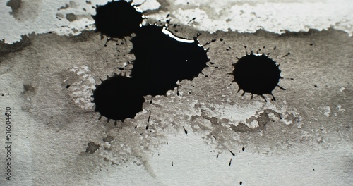 Black ink drops. Paint spatter. Wet dye splash. Dark dirt stain blotch on white grunge stained distressed paper texture abstract background.