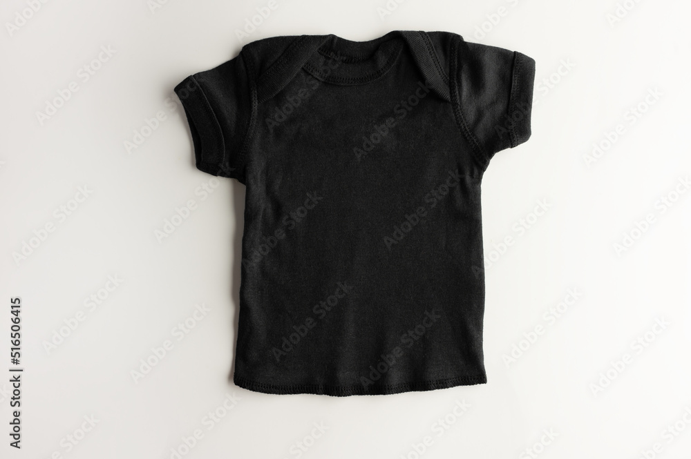 Mockup of a basic black children's T-shirt on a pink background - for a girl. Flat layout for design and print, logo and advertising. Mockup of a basic black children's T-shirt on a pink background - for a girl. Flat layout for design and print, logo and advertising.