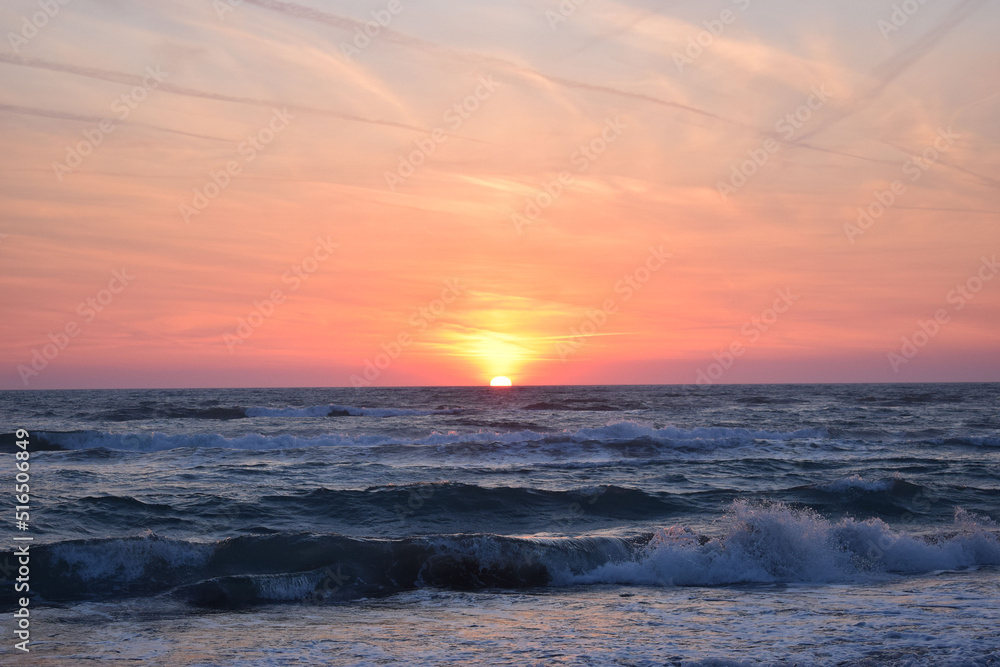A beautiful sunset on the beach in the turbulent ocean
