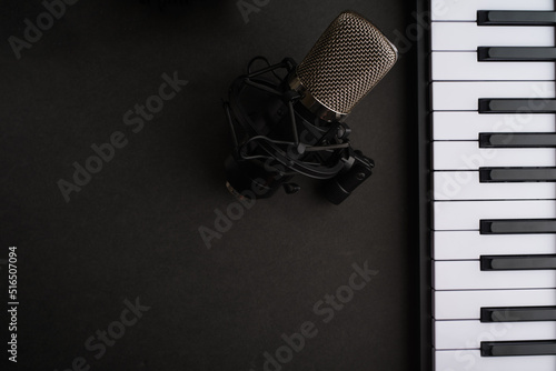Studio microphone and midi keyboard on a gray background. Music, vocals, recording studio. There are no people in the photo. There is free space to insert. Banner, advertisement, invitation.