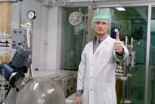 Maintenance service engineer pround smart standing portrait in front of syphon tube cannabis distillation machine 
 photo