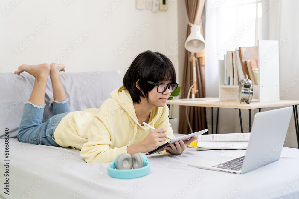 Asian girl using tablet computer and lying on the bed at home. Asian girl using tablet computer and lying on the bed at home.
