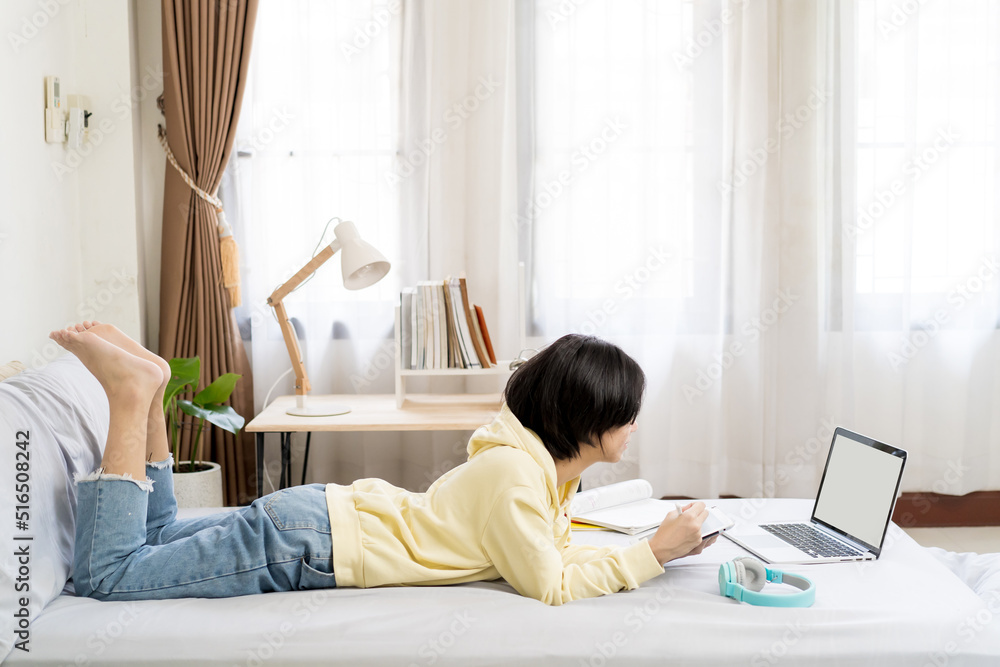 Asian girl using tablet computer and lying on the bed at home. Asian girl using tablet computer and lying on the bed at home.