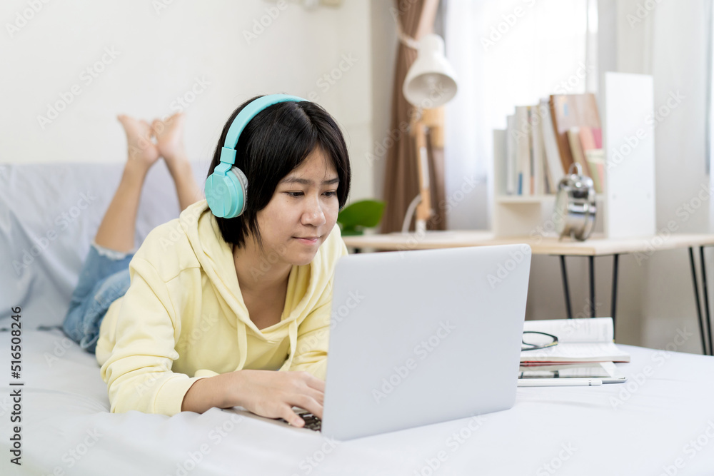 Asian girl using laptop computer and lying on the bed at home. Asian girl using laptop computer and lying on the bed at home.