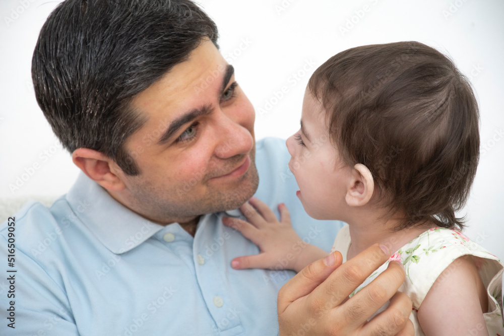 A man in a blue t-shirt is holding his daughter A man in a blue t-shirt is holding his daughter