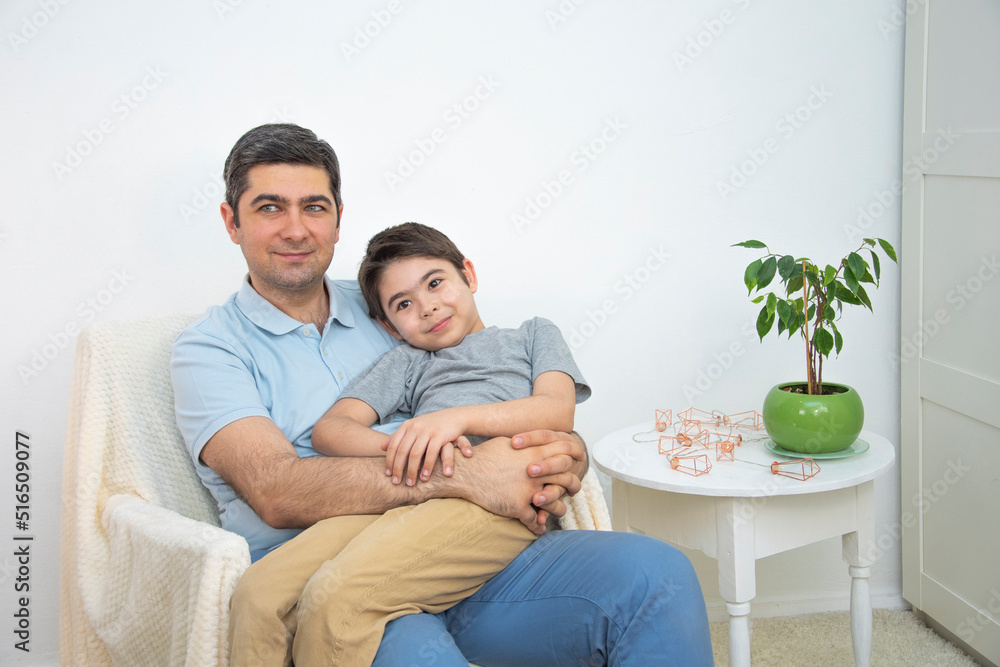 A man in a blue T-shirt is holding his son in his arms A man in a blue T-shirt is holding his son in his arms