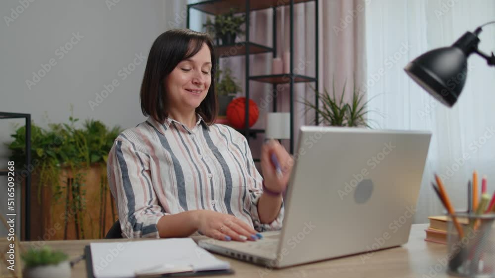 Young woman freelancer sitting at home office desk making video call chat conversation conference use laptop. Adult girl student study working online remote distance job, talking, briefing by webcam Young woman freelancer sitting at home office desk making video call chat conversation conference use laptop. Adult girl student study working online remote distance job, talking, briefing by webcam